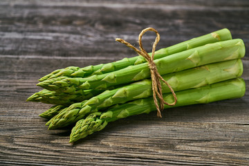 Fresh green shoots of asparagus on a gray wooden background