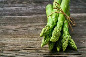 Fresh green shoots of asparagus on a gray wooden background