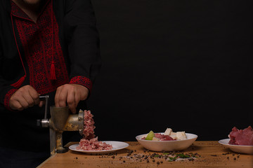 Men's hands making forcemeat with meat grinder.