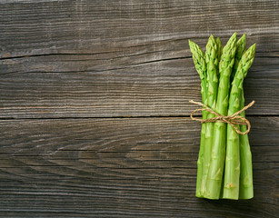 Fresh green shoots of asparagus on a gray wooden background - Powered by Adobe
