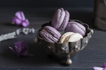 Closeup of macaroons in a silver pot; selective focus background.