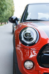 Close-up view of red sports car headlight and bumper