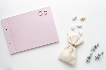 Wedding wish book, candy, weddings rings and oregano branches. Top view.