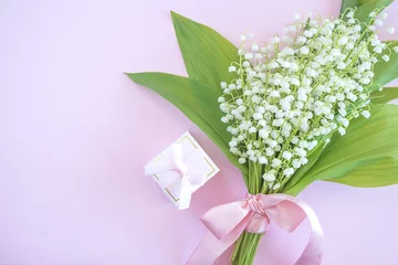 Fototapeten Rosa Geschenkbox mit Verlobungsring und Blumenstrauß aus Maiglöckchen auf rosa Hintergrund mit Kopierraum © stsvirkun