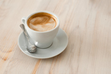 One white cup of espresso with coffee spoon in coffee shop - vintage effect style pictures