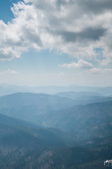 A beautiful view of the snow-capped mountains of the Carpathians from the top of Goverly in spring in a beautiful sunny day with light clouds. Carpathians, Goverla, Ukraine.