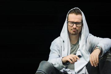 Portrait of fashionable man against black wall.