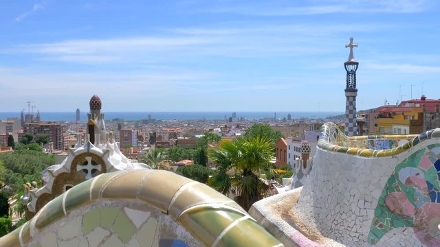 Tilt up view from bench Mosaics to Barcelona's skyline as seen from Park Guell