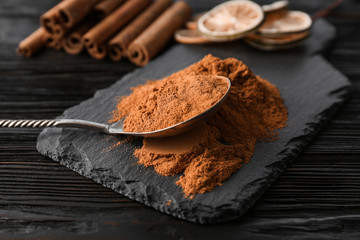 Aromatic cinnamon powder and sticks on wooden background