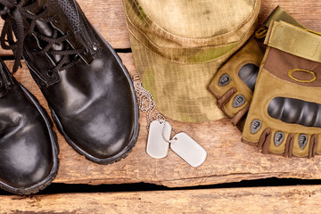 Soldier's clothes and attributes flat lay. Top view. Wooden desk surface background.