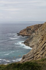 Fototapeta na wymiar Views of the wild Atlantic Ocean with beautiful cliffs in Cape Espichel