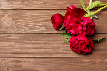 Naklejka na ściany i meble Beautiful blooming peony flowers on wooden background, top view