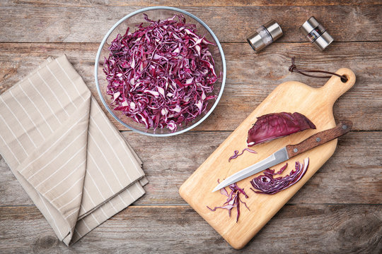 Flat lay composition with chopped purple cabbage on wooden background