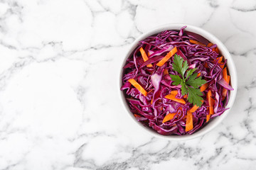 Bowl with chopped red cabbage on marble table, top view