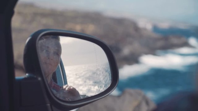 reflection of the silhouette of lonely woman in a car mirror