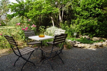 Table et chaise sur terrasse ombragée et bassin d'agrément