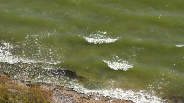 Waves roll on the shore, a view from above.