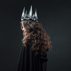 Portrait of a Gothic Princess. Beautiful young brunette woman in metal crown and black cloak. © Ulia Koltyrina