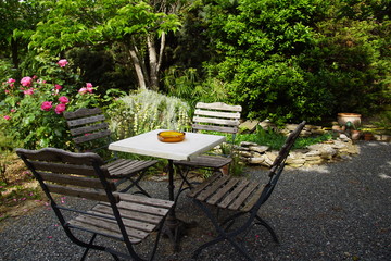 Table et chaise sur terrasse ombragée et bassin d'agrément