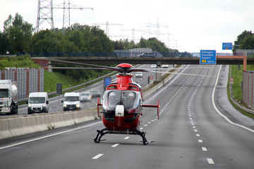 Ein Rettungshubschrauber steht auf einer deutschen Autobahn.