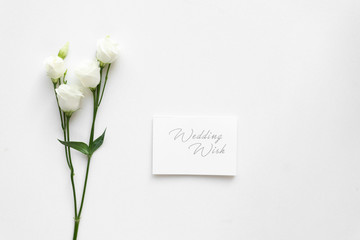 Wedding wish card with roses, on white marble. Top view.