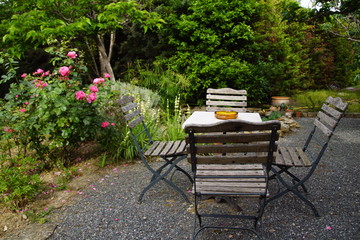 Table et chaise sur terrasse ombrag&eacute;e et bassin d'agr&eacute;ment