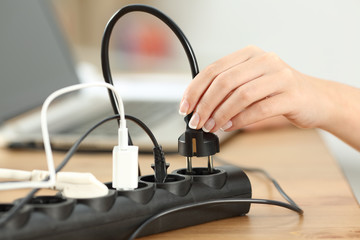 Woman hand plugging a plug in an electrical socket