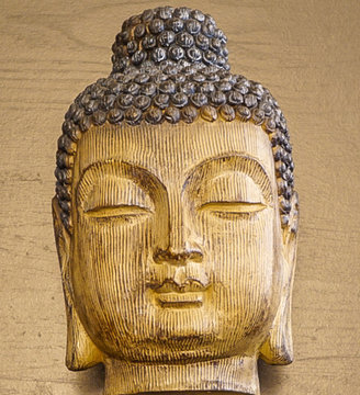 Wooden Carved Buddist Head with wood grain background