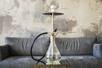 Hookah on the background of a gray sofa and a wall