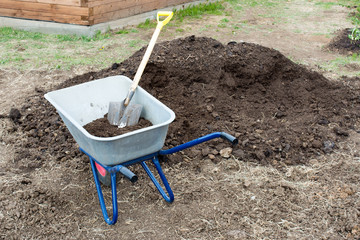 Garden wheelbarrow, shovel and humus.