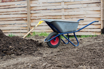 Garden wheelbarrow, shovel and humus.