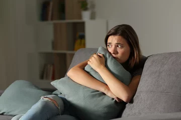 Fotobehang Scared teen at home embracing pillow © Antonioguillem