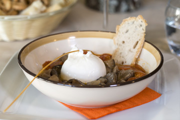 piatto di funghi con pomodoro e mozzarella di bufala sul tavolo di un ristorante