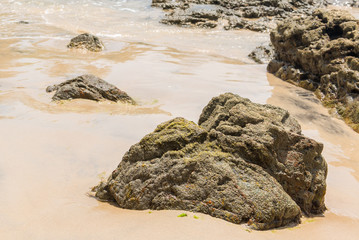 Rocks by the beach with waves splahes