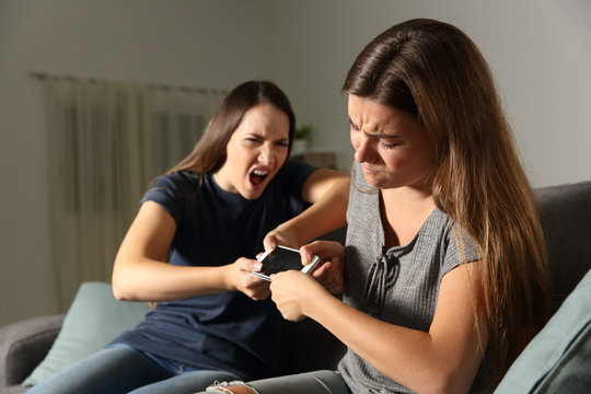 Friends or sisters fighting for a smart phone