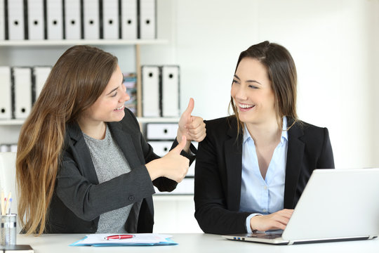 Office worker congratulating her colleague