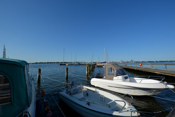 Fototapeta premium Motorboote im Hafen Altefähr mit Blick zur Rügenbrüke und Skyline von Stralsund