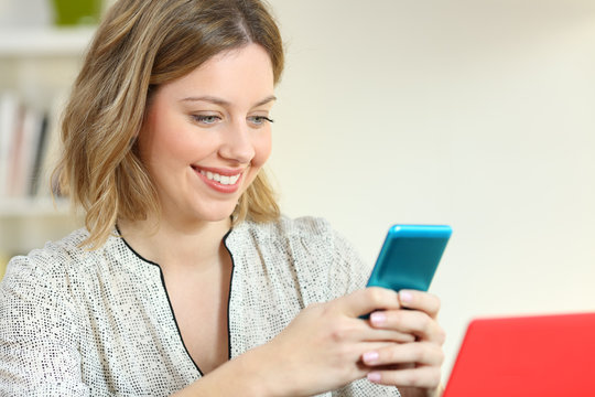 Woman messaging using a smart phone at home