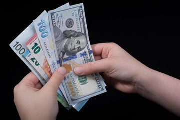 Hand holding American dollar  isolated on black background