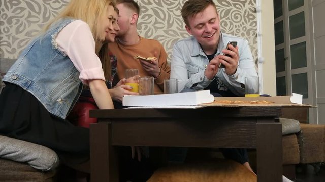 Hungry cat is under the table, while people are eating