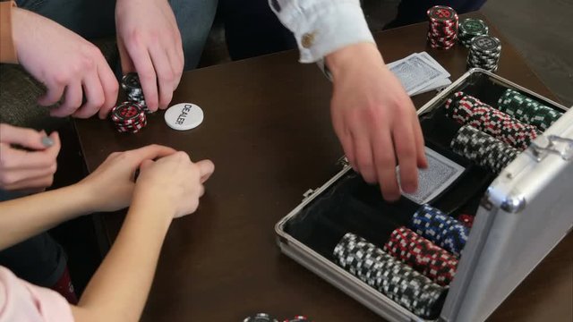 Male hands take cards and chips from the poker case on the table