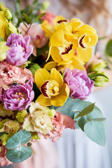 Spring bouquet of flowers with orchids, tulips and eustoma. Pink yellow flower arrangement