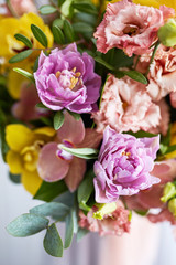 Spring bouquet of flowers with orchids, tulips and eustoma. Pink yellow flower arrangement