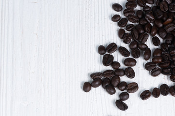 Roasted coffee beans on white wood table. coffee background with copy space.