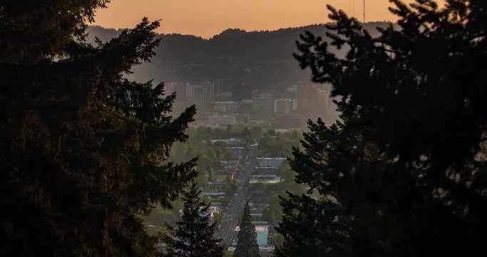 A timelapse of Portland Oregon from mt. Tabor at sunset. This time lapse shot shows cars on Hawthorne boulevard, and trees in the foreground.