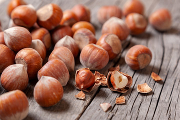 Heap Hazel and two nuts with  broken shell on an old wooden table.