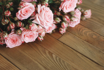 Pink Beautiful Roses Bouquet over Wooden Table. Top view Copy Space. Vintage Greeting Card