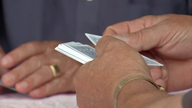 Close up of a game of a cards as they are dealt and sorted in hands