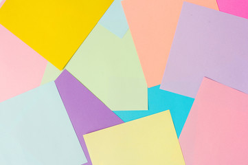 Color paper on a white background for a lesson of origami. the scattered color paper alternately