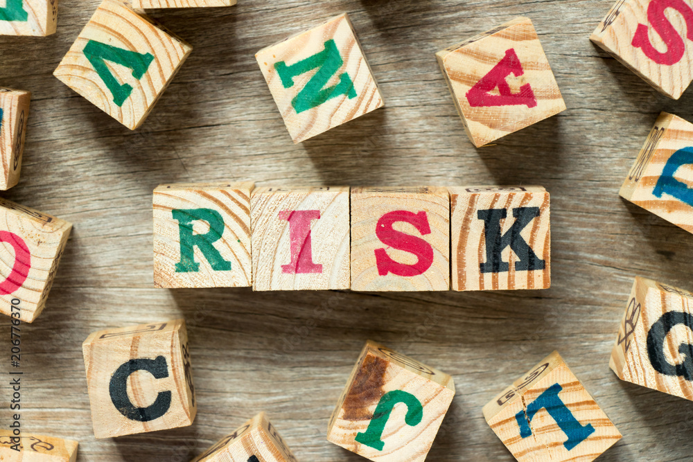 Poster Letter block in word risk with another on wood background